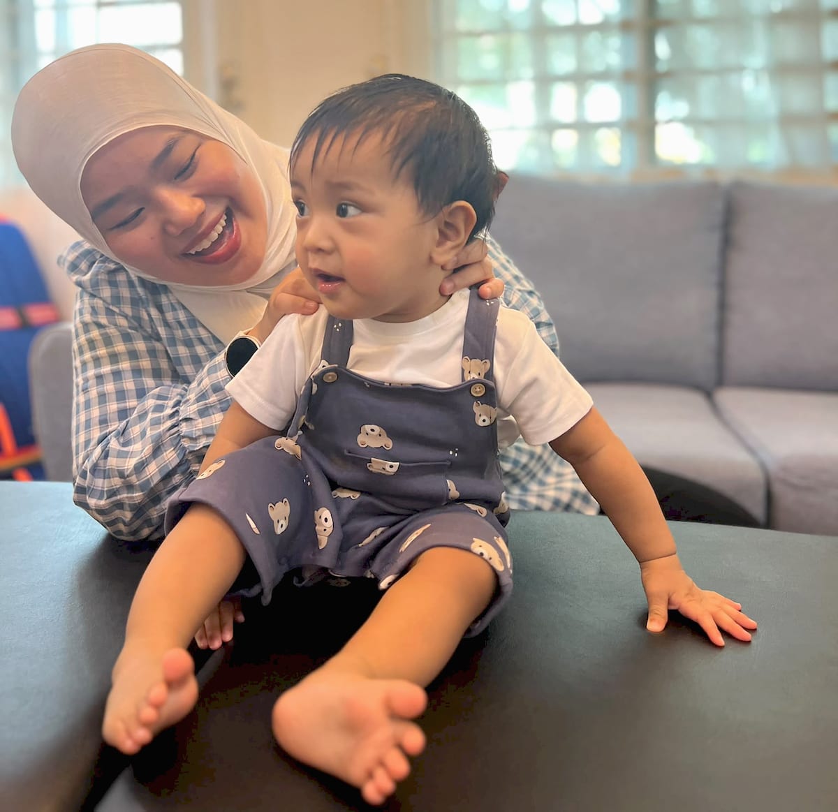 Nurul smiling with a baby during a home visit